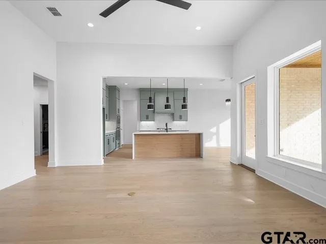 a view of a kitchen with kitchen island a sink stainless steel appliances and cabinets