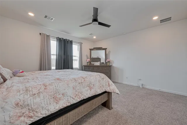 a spacious bedroom with a bed and a chandelier