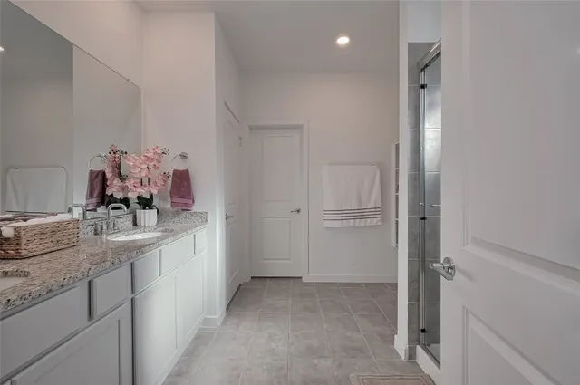 a bathroom with a granite countertop sink a mirror and a shower