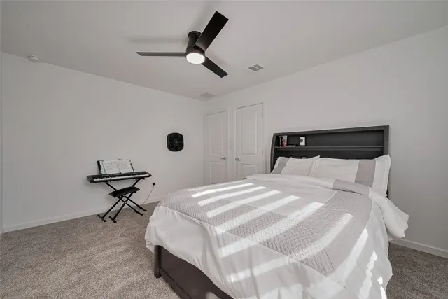 a bedroom with a bed and a ceiling fan