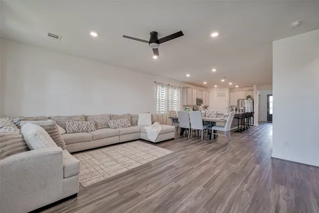 a living room with furniture and a wooden floor