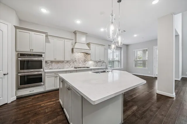 a kitchen with a stove a refrigerator and a sink