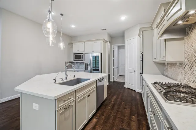 a kitchen with sink stove and refrigerator