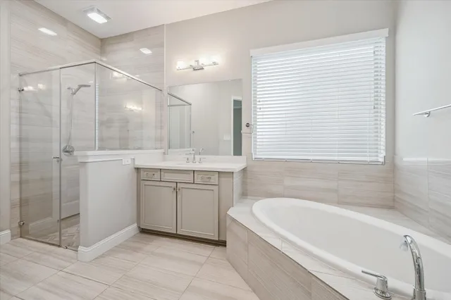 a bathroom with a granite countertop sink a mirror and a bathtub