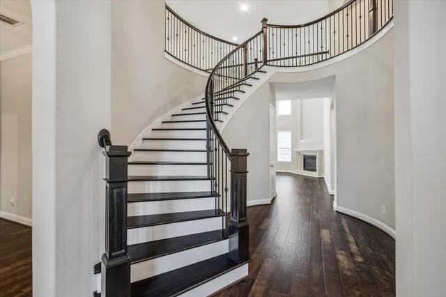 a view of staircase with wooden floor and white walls