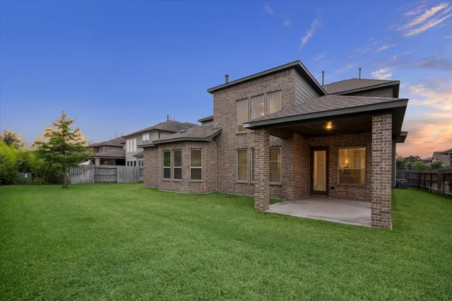 a view of a house with a big yard and large trees