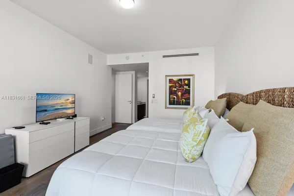 a bedroom with a bed and a flat screen tv