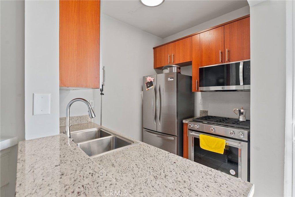620 South Gramercy Place, Unit 412 Los Angeles, CA 90010 - Photo 8 of 41 a kitchen with stainless steel appliances granite countertop a sink a stove and refrigerator