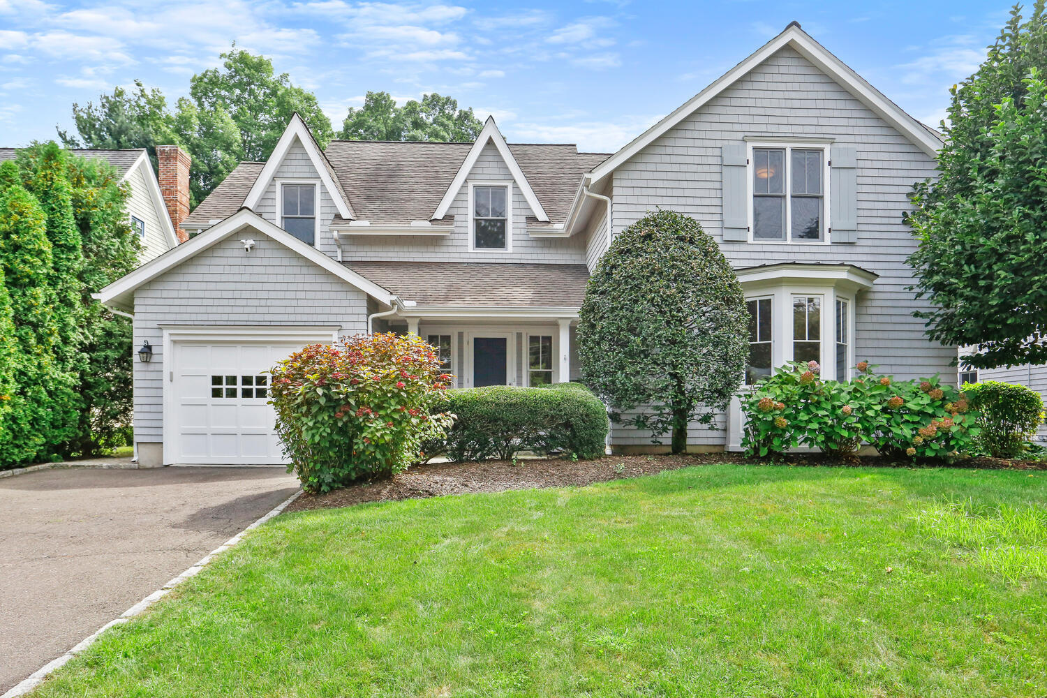 12 Ridgewood Road Rowayton, CT 06853 - Photo 2 of 35 a front view of a house with a garden and plants