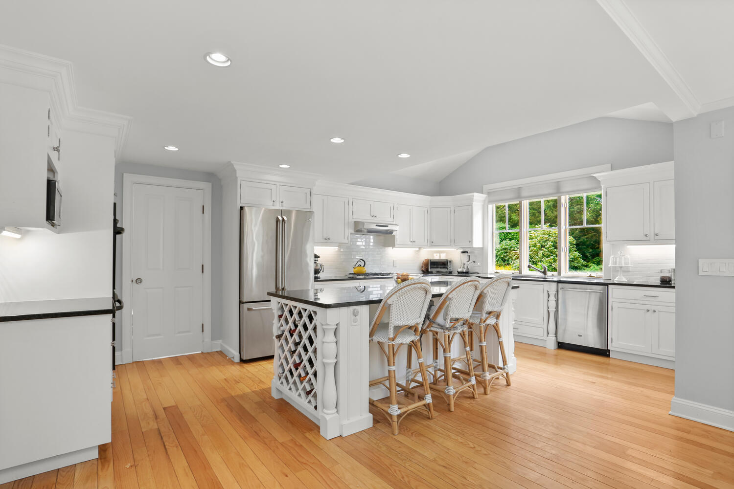 12 Ridgewood Road Rowayton, CT 06853 - Photo 10 of 35 a kitchen with stainless steel appliances granite countertop a refrigerator a sink a stove a dining table and chairs with wooden floor