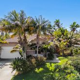 a front view of a house with a yard and a garden