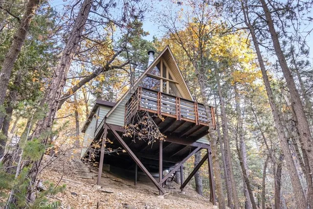 a front view of a house with a tree