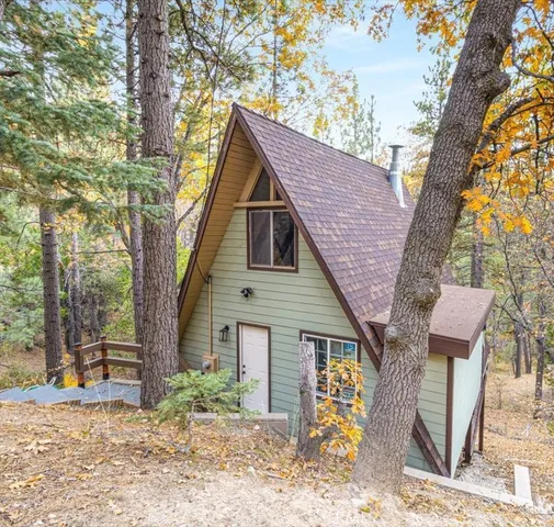 a front view of house with yard and trees around