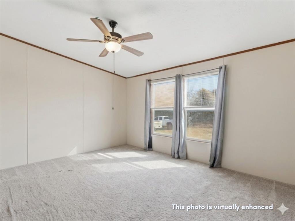 2722 Denver Road Sunset, TX 76270 - Photo 11 of 19 Carpeted room featuring a ceiling fan with integrated lighting, two windows with blinds and drapes, and paneled walls with wood-finish trim