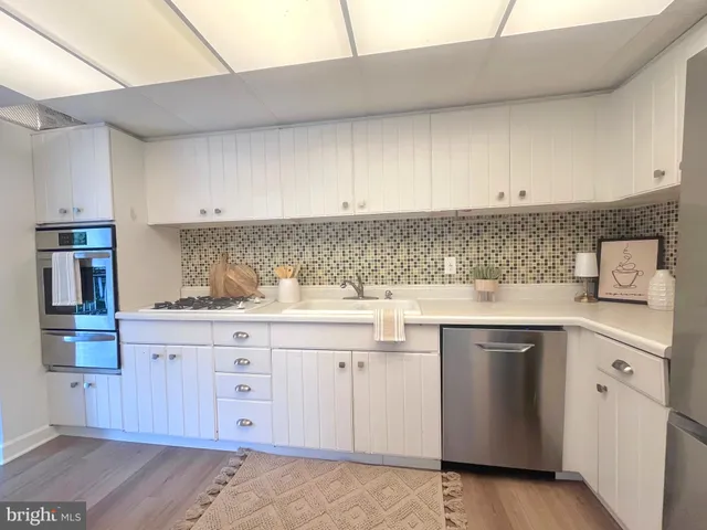 a kitchen with cabinets appliances a sink and a counter top space
