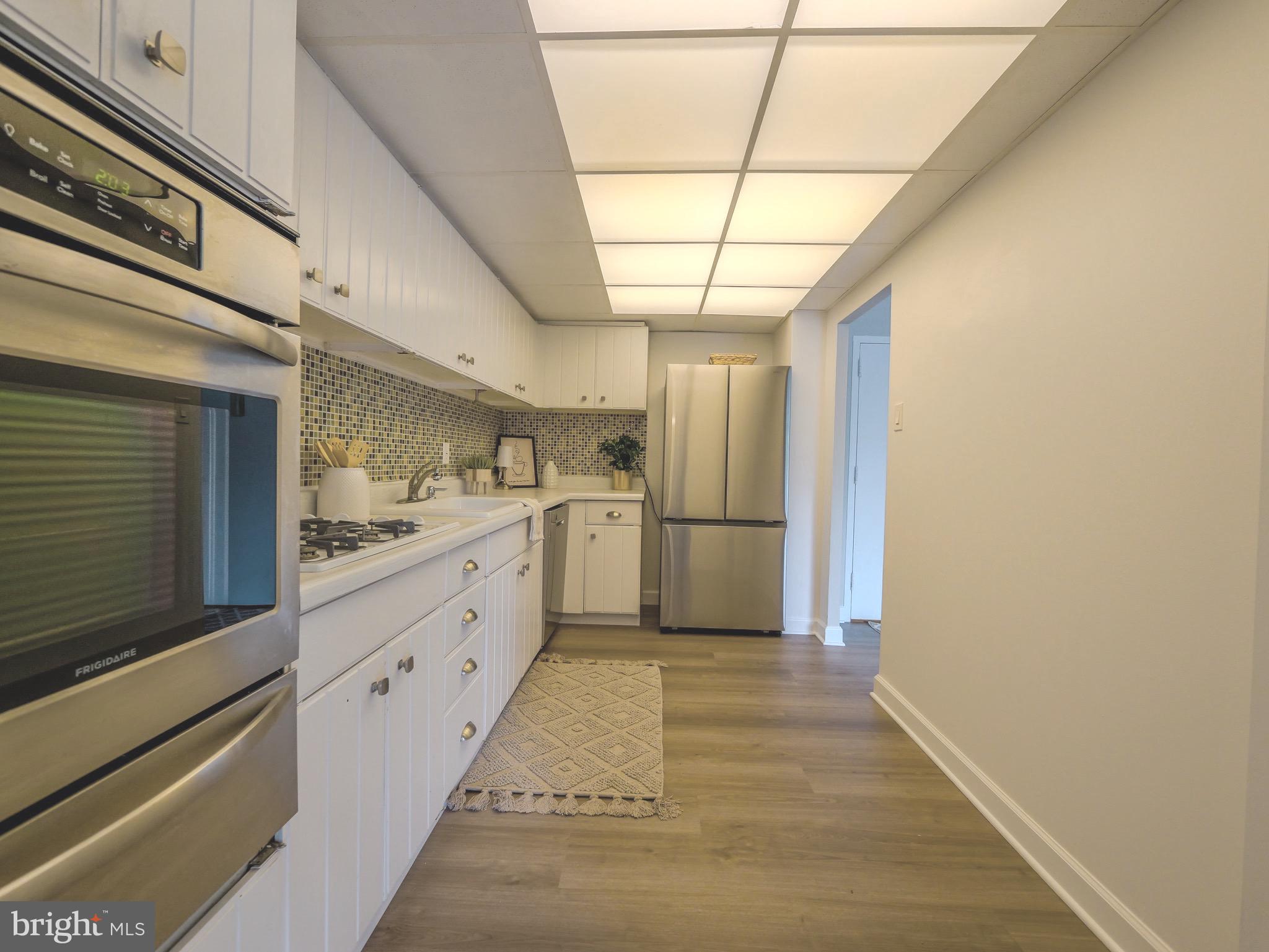 801 Yale Avenue, Unit 107 Swarthmore, PA 19081 - Photo 13 of 35 a kitchen with cabinets and wooden floor