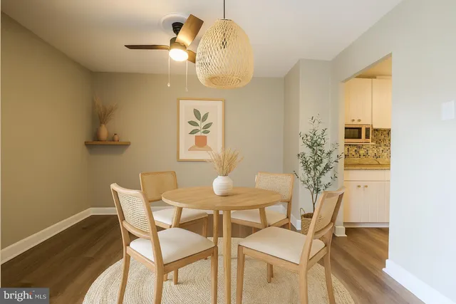 a dining room with chandelier and wooden floor