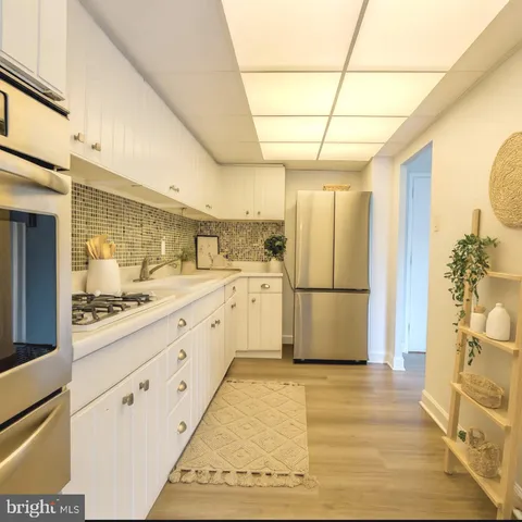 a large kitchen with a stove a refrigerator and a sink