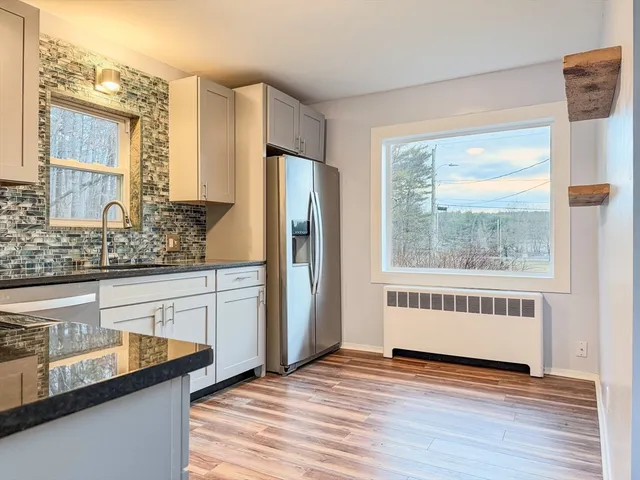 a view of kitchen with granite countertop cabinets and wooden floor