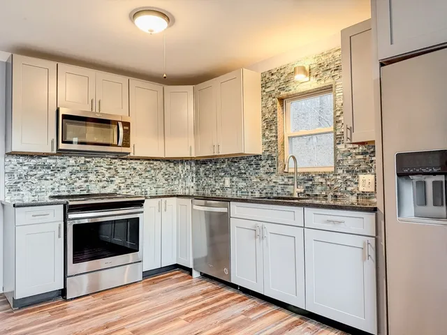 a kitchen with stainless steel appliances granite countertop a stove a microwave and a sink