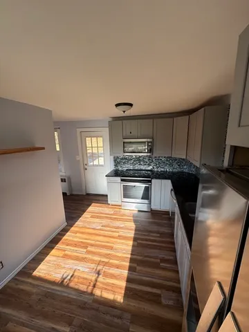 a kitchen with stainless steel appliances kitchen island granite countertop a stove and cabinets