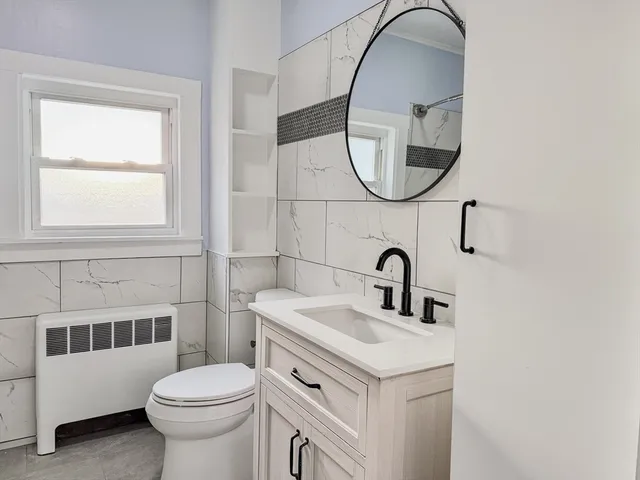 a bathroom with a sink a toilet and a mirror