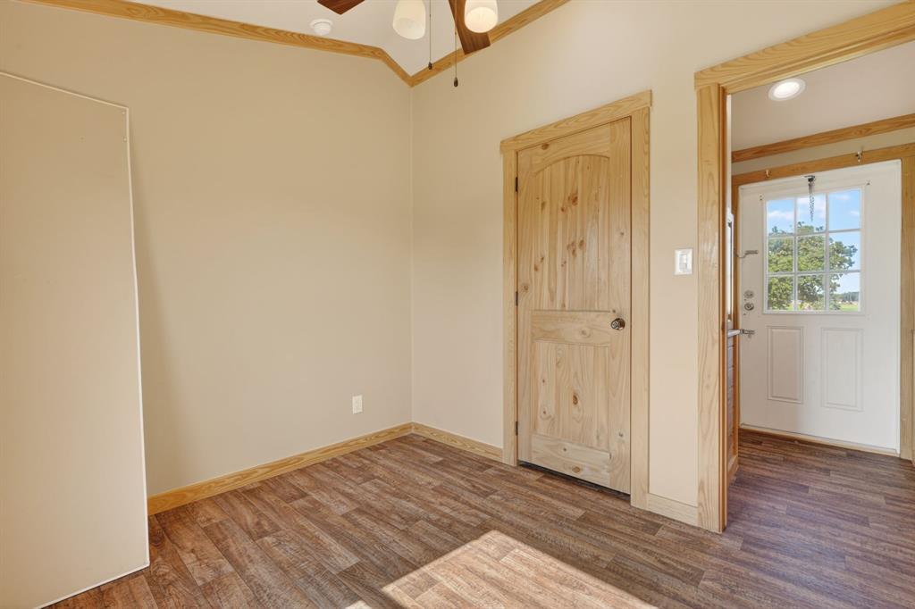 2401 Lamkin Road Mineral Wells, TX 76067 - Photo 23 of 36 a view of an empty room with wooden floor and a window