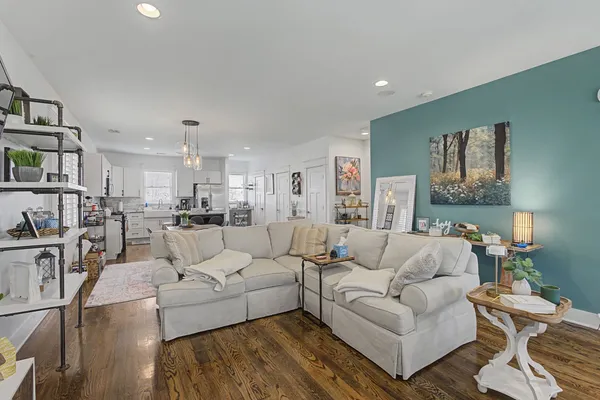 a living room with furniture and a view of kitchen
