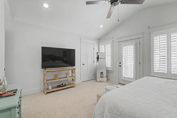 a bedroom with a bed and a flat tv screen on wall