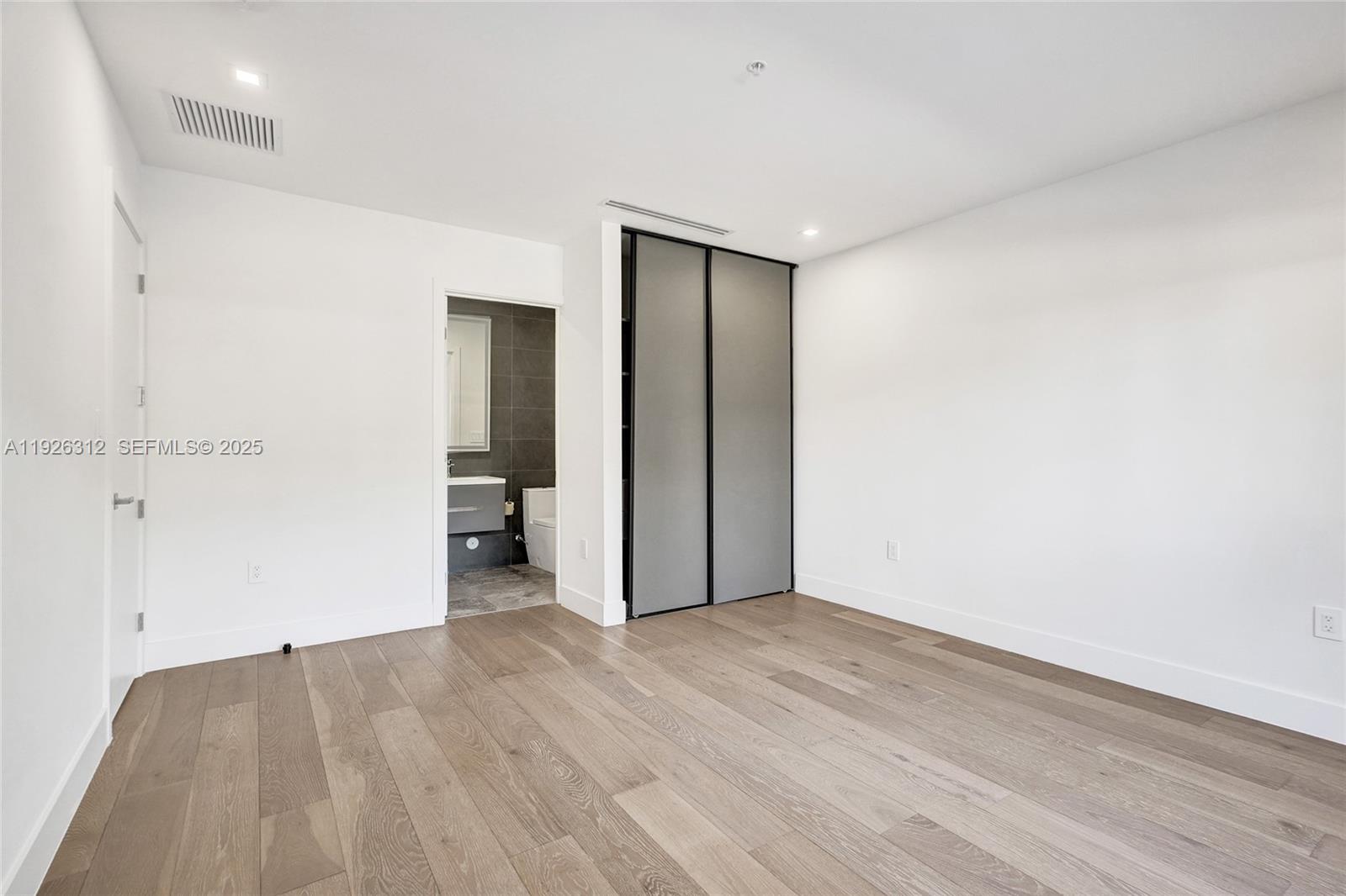 200 Sunrise Drive, Unit 200A Key Biscayne, FL 33149 - Photo 21 of 45 an empty room with wooden floor and bathroom