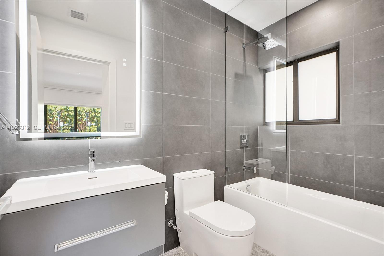 200 Sunrise Drive, Unit 200A Key Biscayne, FL 33149 - Photo 23 of 45 a bathroom with a sink toilet a mirror and shower