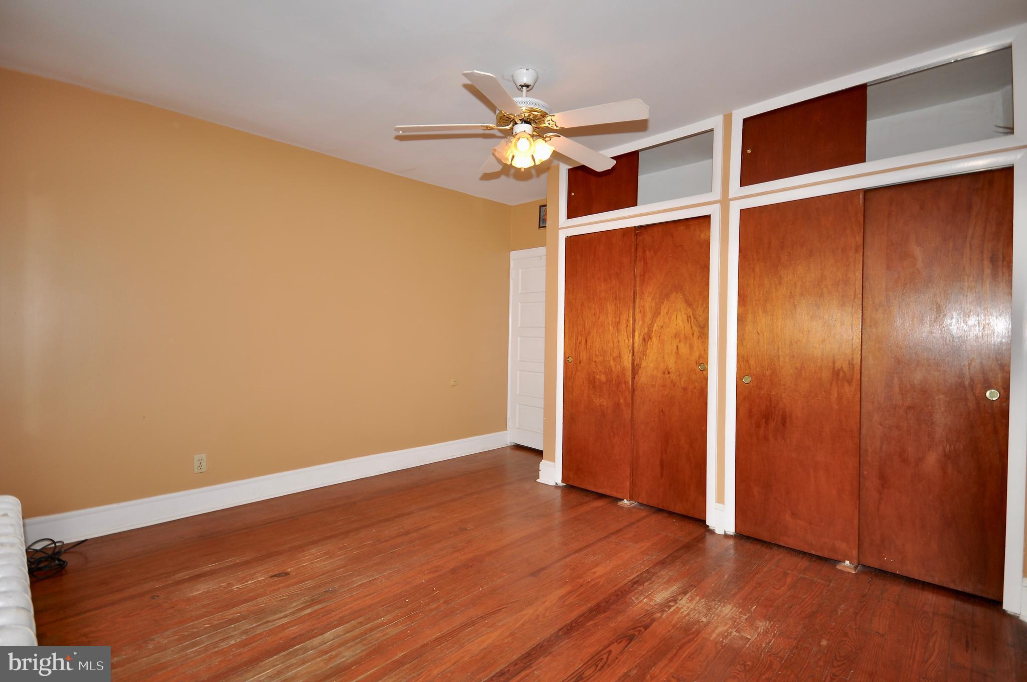 4566 Bermuda Street Philadelphia, PA 19124 - Photo 15 of 30 an empty room with wooden floor closet and chandelier fan