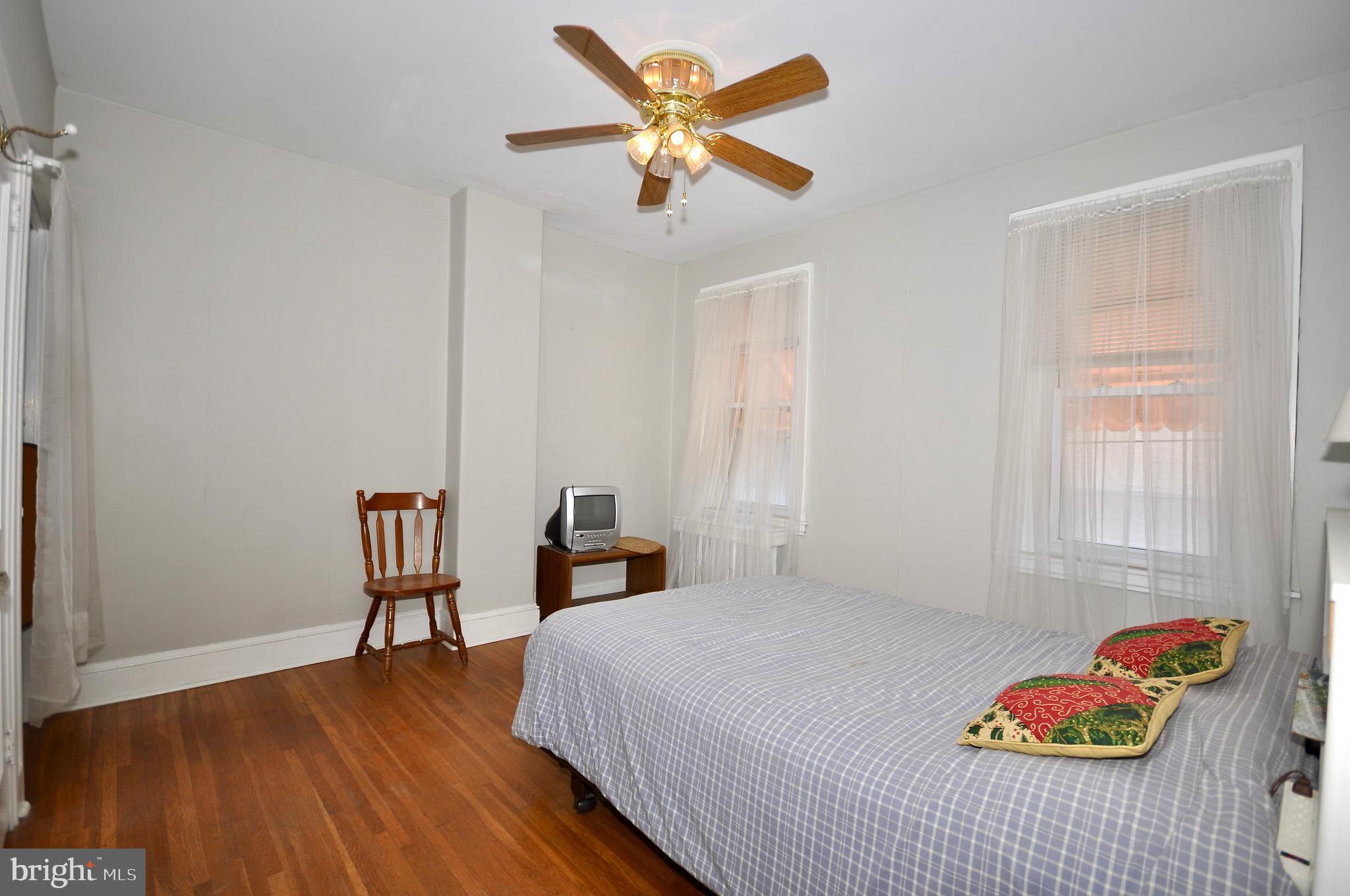 4566 Bermuda Street Philadelphia, PA 19124 - Photo 26 of 30 a bedroom with a bed and a table in it