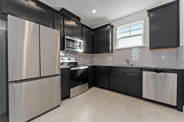 a kitchen with stainless steel appliances a refrigerator sink and microwave