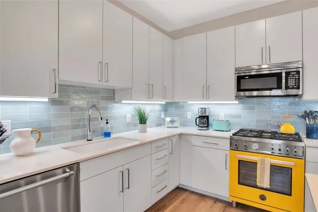 a kitchen with stainless steel appliances granite countertop white cabinets a sink and dishwasher