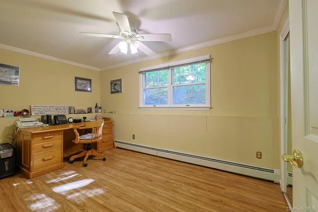 a view of a workspace with furniture and a window