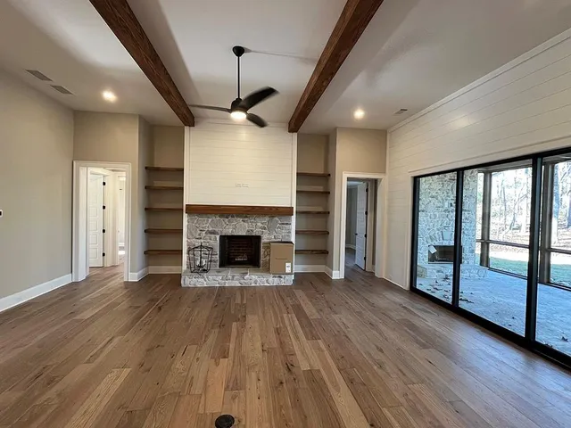 a view of a livingroom with wooden floor a fireplace and window