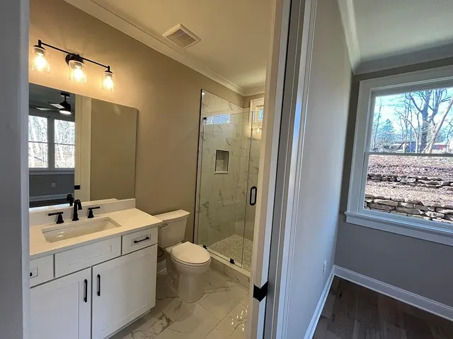 a bathroom with a granite countertop sink toilet and shower