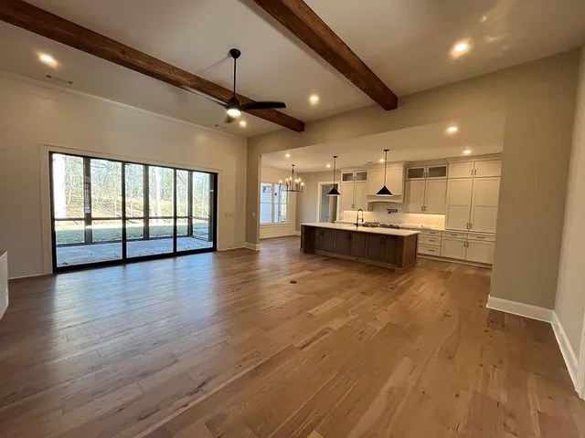 a view of a big room with wooden floor and windows