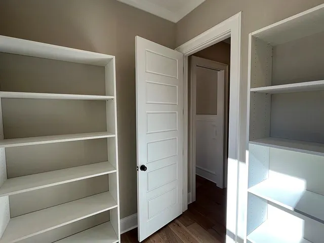 a view of walk in closet with empty racks