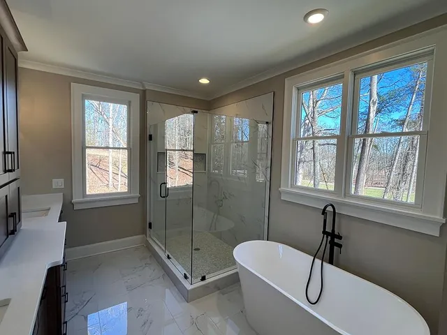 a spacious bathroom with a tub shower and window