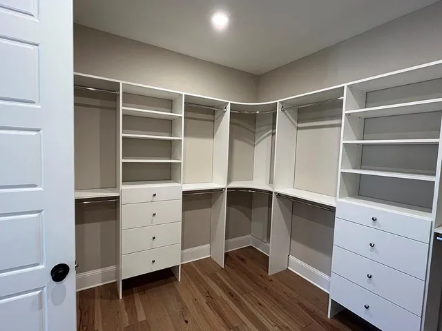 a view of walk in closet with empty racks