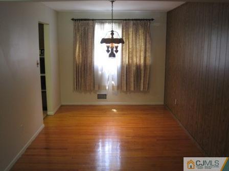 21 Daniel Road Spotswood, NJ 08884 - Photo 5 of 12 an empty room with wooden floor and windows