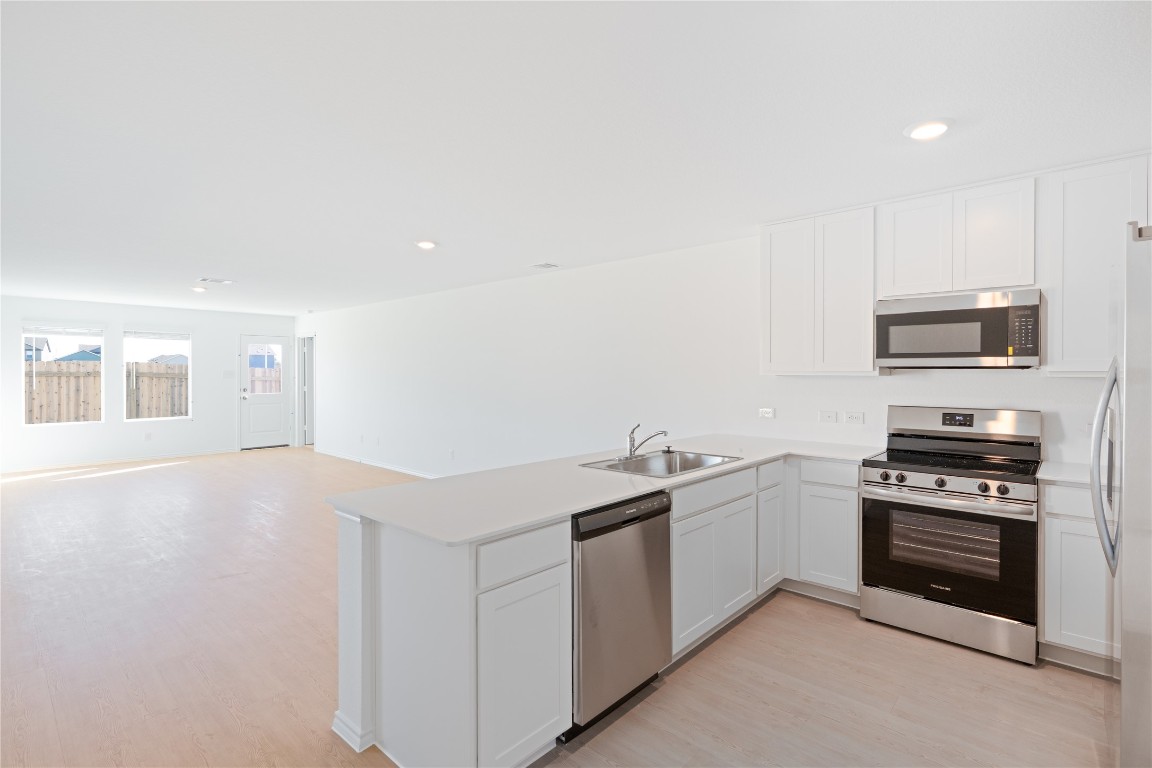 241 Kings Row Lane Jarrell, TX 76537 - Photo 27 of 27 a kitchen with stainless steel appliances a stove a sink and a microwave