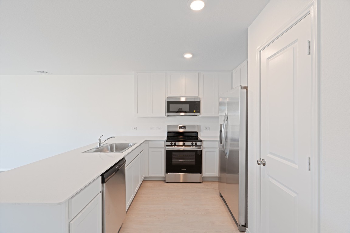 241 Kings Row Lane Jarrell, TX 76537 - Photo 9 of 27 a kitchen with a sink and stainless steel appliances