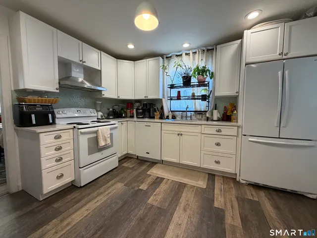 a kitchen with white cabinets and white appliances