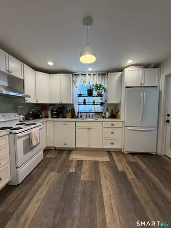 a kitchen with white cabinets and white appliances