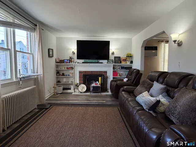 a living room with furniture a flat screen tv and a fireplace