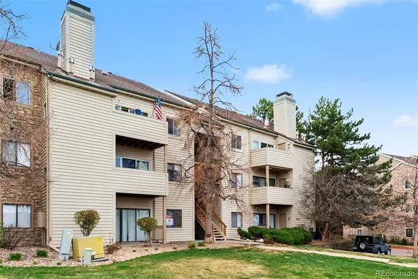 a front view of a white building with yard