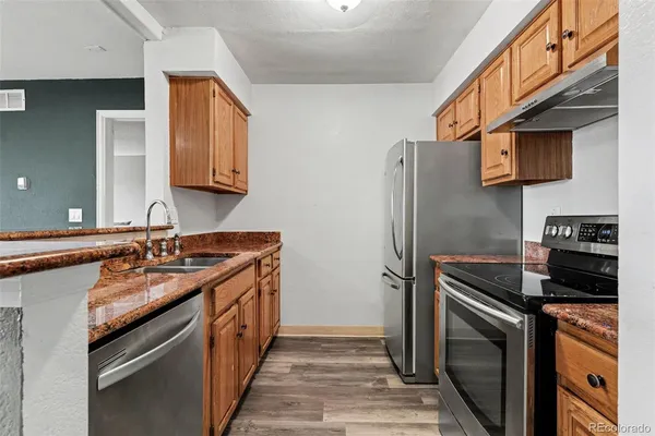 a kitchen with stainless steel appliances granite countertop a sink stove and refrigerator